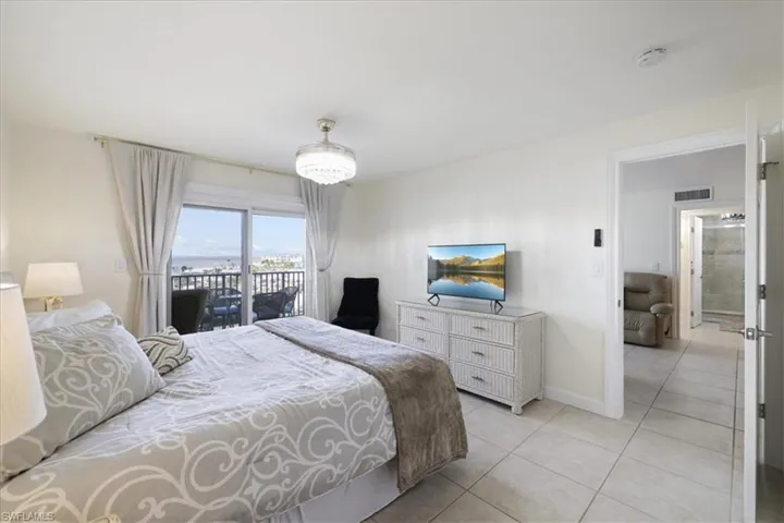 Bedroom with access to outside and light tile patterned floors