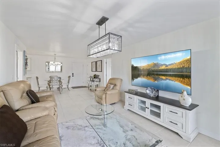 Living area with suspended lighting and light tile patterned floors