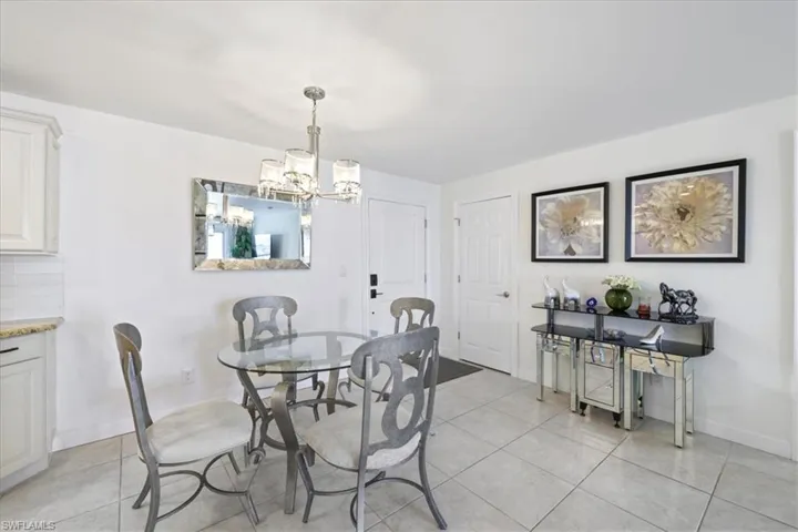 Dining area with suspended lighting and light tile patterned floors