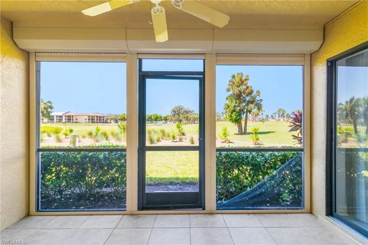 Doorway to outside featuring a textured wall, tile patterned floors, a textured ceiling, plenty of natural light, and golf course view