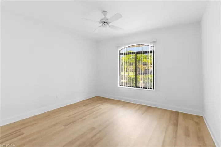 Empty room with light wood-style floors and a ceiling fan