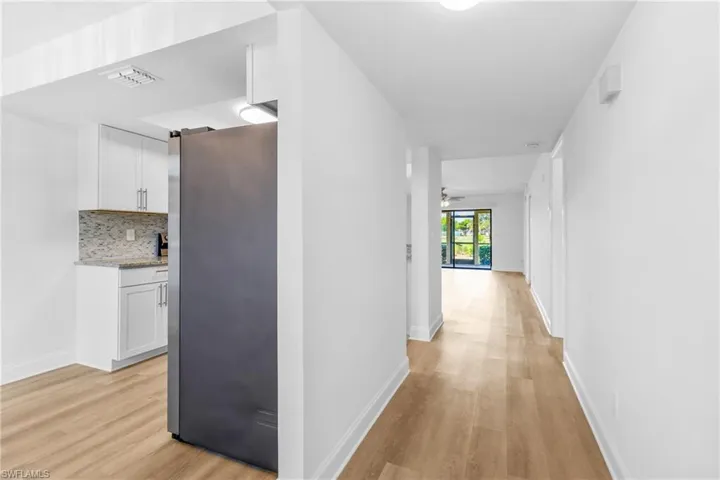 Corridor featuring light wood finished floors and baseboards