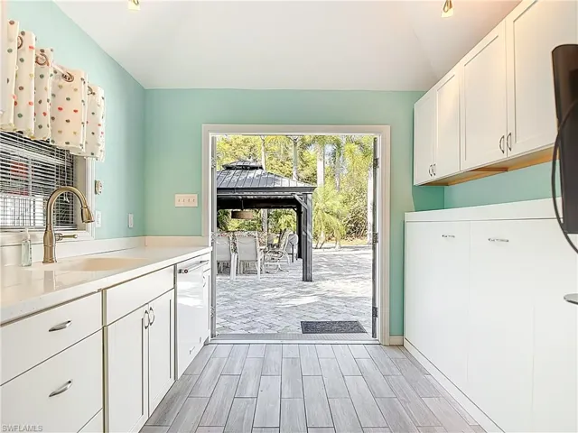 Laundry room featuring wood finish floors,  ceiling, and cabinet space