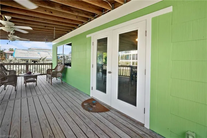 Wooden terrace featuring french doors and ceiling fan