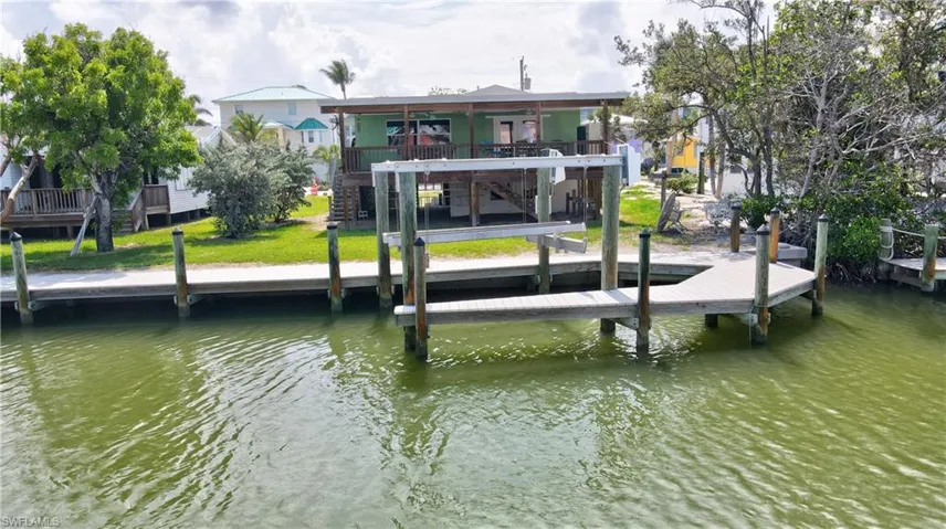 Dock featuring a water view, stairway, and a yard