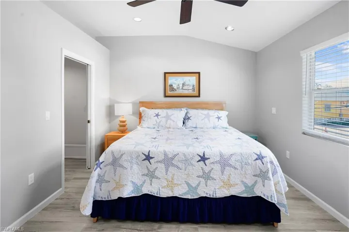Bedroom with light wood-type flooring, baseboards, vaulted ceiling, ceiling fan, and recessed lighting