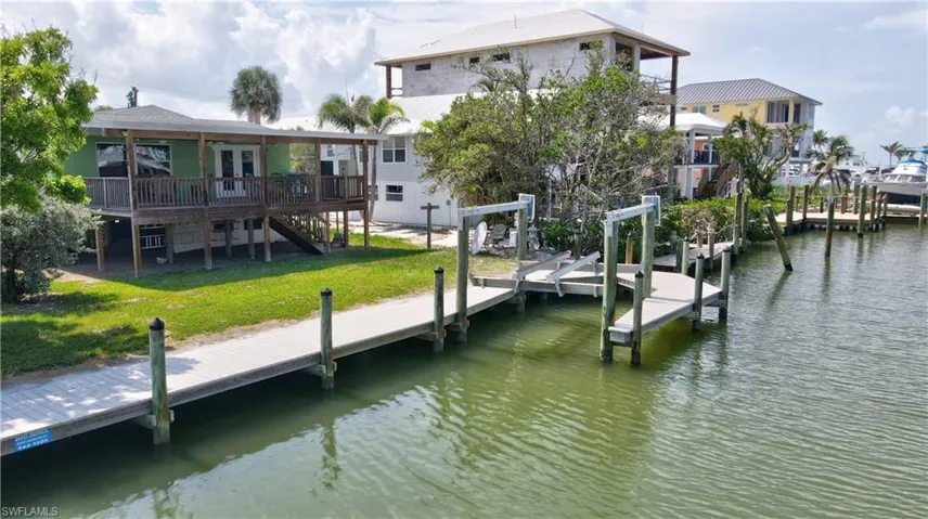 Dock with a lawn, a deck with water view, and stairway