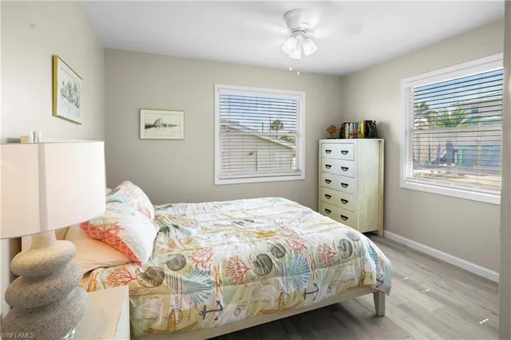 Bedroom with light wood finished floors, baseboards, and a ceiling fan