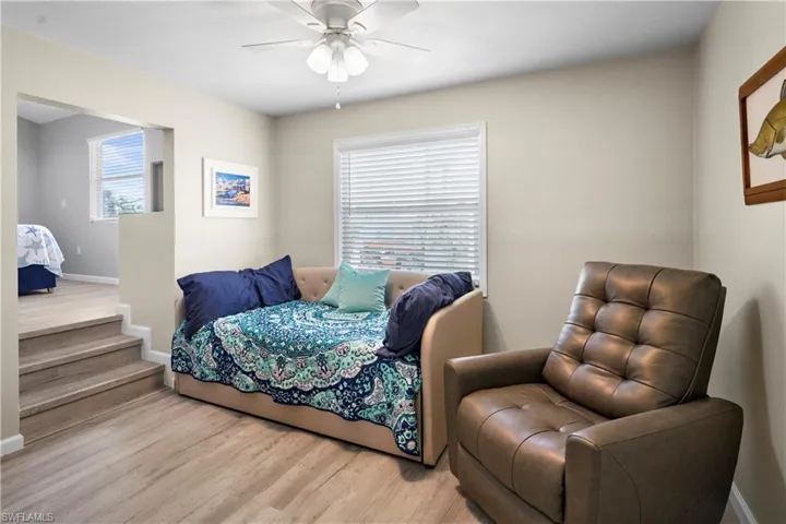 Bedroom with wood finished floors, multiple windows, and baseboards