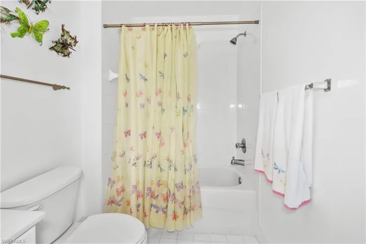 Bathroom with shower / bath combo, vanity, and tile patterned floors