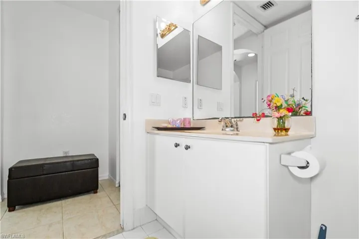 Half bathroom featuring vanity and light tile patterned flooring