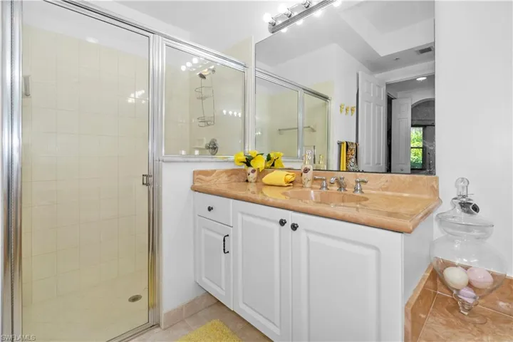 Full bath with vanity, a stall shower, and light tile patterned flooring