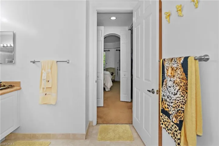 Bathroom featuring light colored carpet, connected bathroom, vanity, and recessed lighting