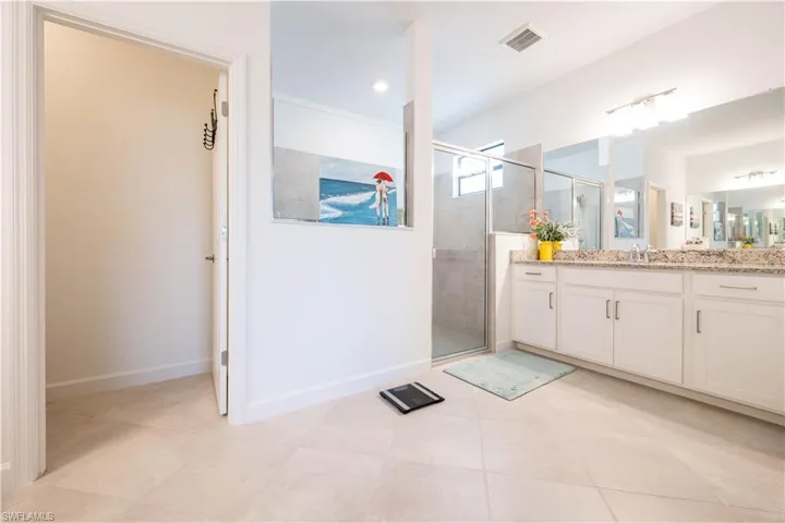 Full bath with vanity, a stall shower, and light tile patterned flooring