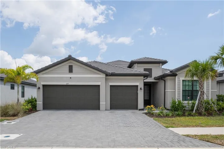 View of front of home featuring decorative driveway, stucco siding, an attached garage, and a tiled roof