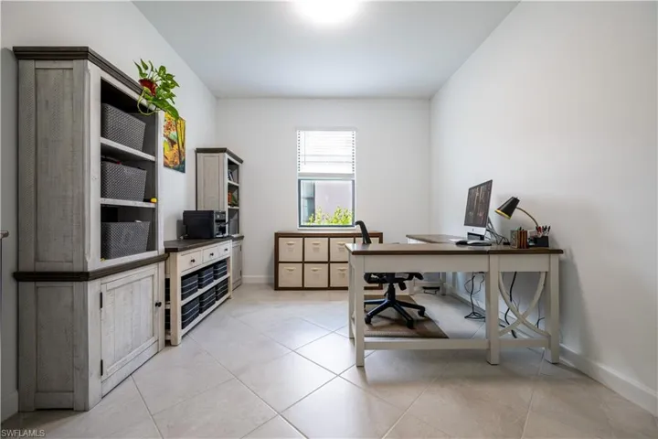 Office area with light tile patterned flooring and baseboards
