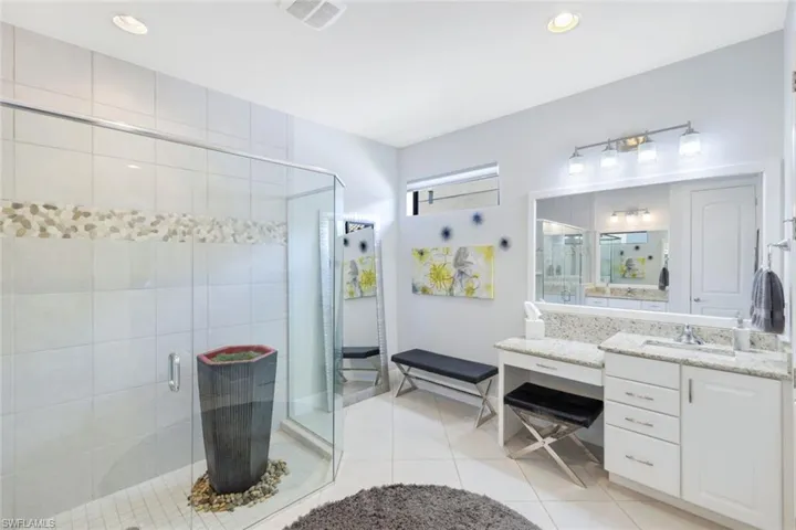 Bathroom with tile patterned flooring, vanity, and an enclosed shower