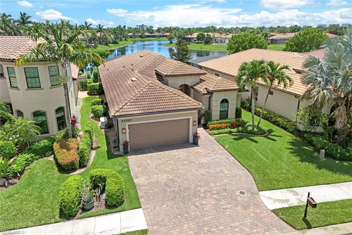 Mediterranean / spanish-style house with a garage, a water view, and a front yard