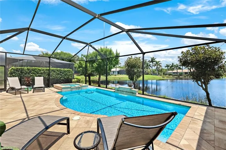 View of pool featuring a patio area, an in ground hot tub, a water view, and a lanai