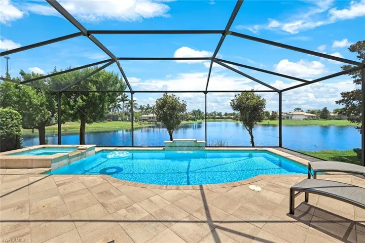 View of swimming pool with a patio area, an in ground hot tub, a water view, and a lanai