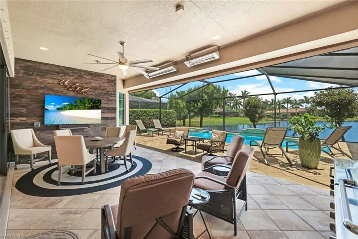 View of patio with ceiling fan and a lanai