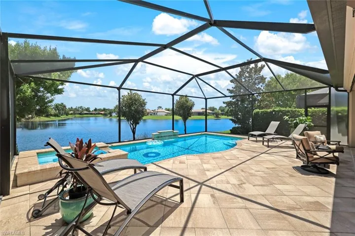 View of pool with a patio, a water view, and a lanai