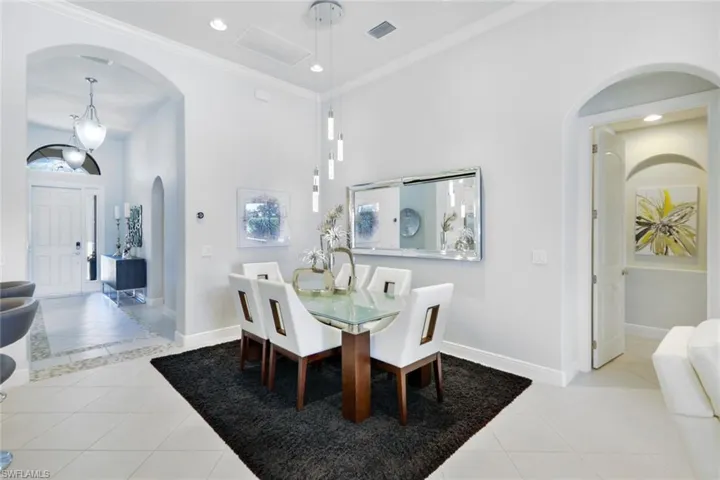 Tiled dining space featuring ornamental molding