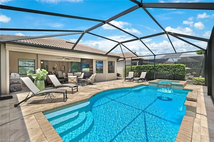 View of swimming pool featuring an in ground hot tub, a patio, ceiling fan, and a lanai