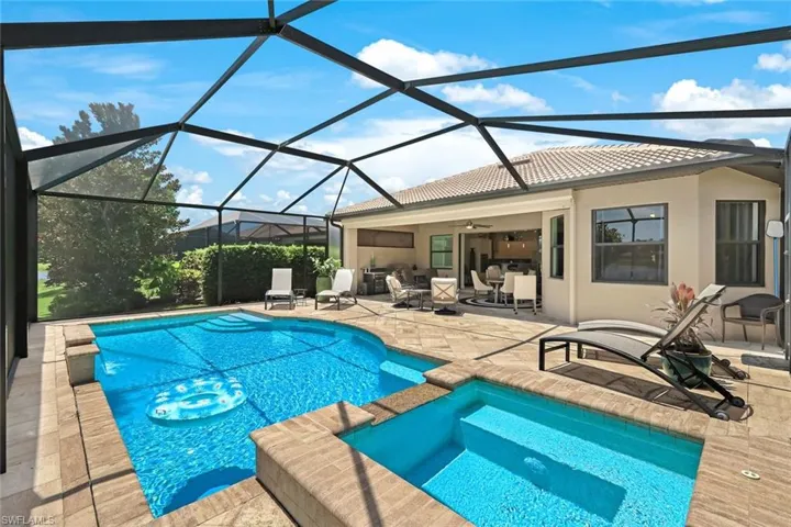 View of swimming pool featuring an in ground hot tub, a patio, ceiling fan, and glass enclosure