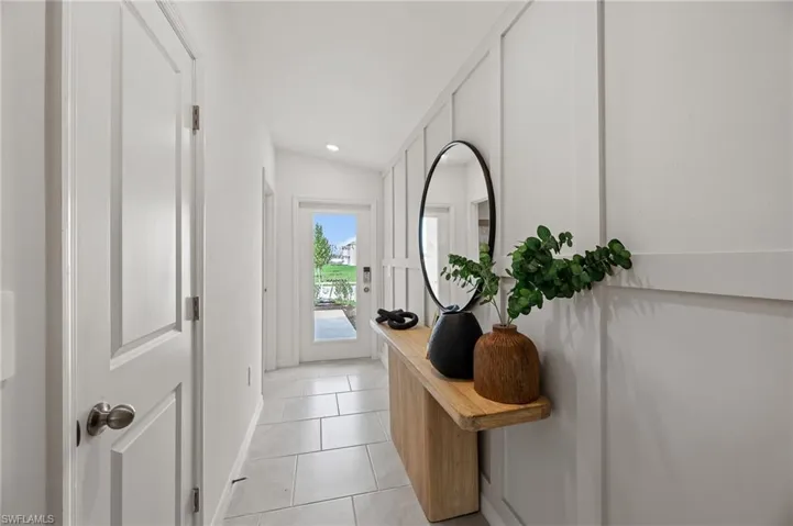 Doorway to outside featuring tile patterned floors and baseboards