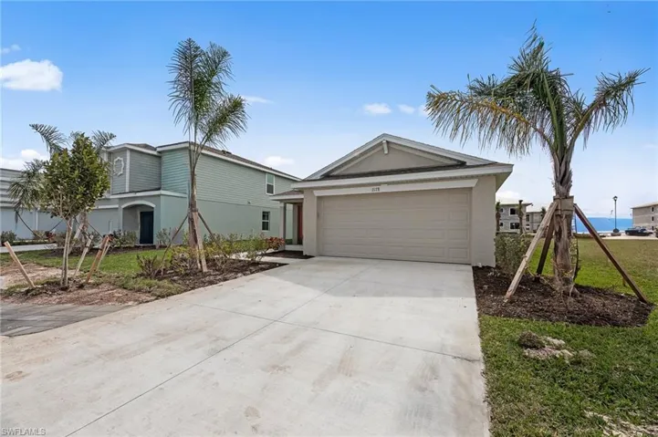 Ranch-style home with concrete driveway, stucco siding, and an attached garage