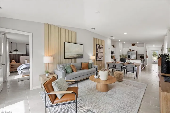 Living room with lofted ceiling, recessed lighting, and light tile patterned flooring