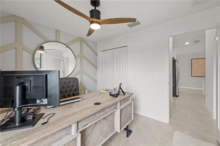 Office space featuring light tile patterned floors and a ceiling fan