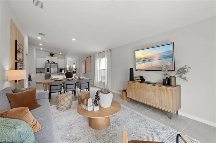 Living area featuring recessed lighting, light tile patterned floors, and lofted ceiling