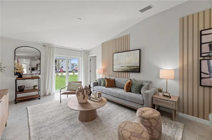 Living room with vaulted ceiling and light tile patterned floors