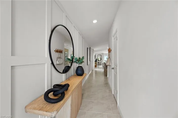 Hall with light tile patterned flooring and recessed lighting