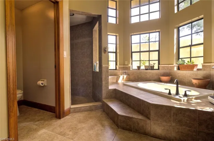 Master Bathroom featuring tile floors, separate shower and tub, and toilet