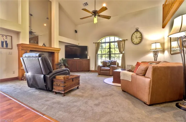 Family room featuring high vaulted ceiling, ceiling fan, and carpet floors