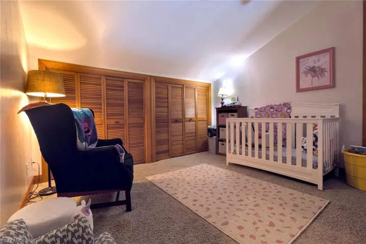 Guest bedroom featuring lofted ceiling, and multiple closets