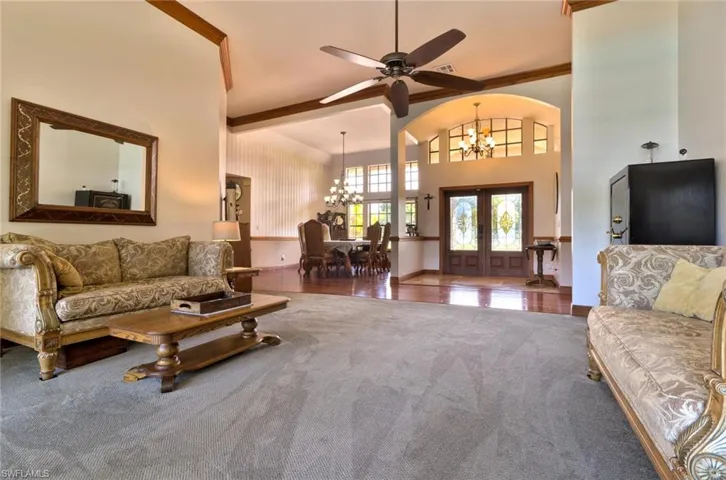 Living room featuring volume ceilings, french doors leading to expansive lanai and  outdoor entertaining area
