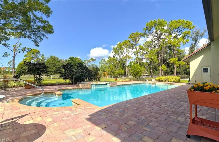 View of lap pool and spa featuring an extensive pavered patio area