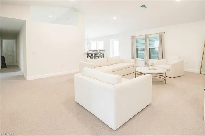 Living room with light colored carpet and recessed lighting