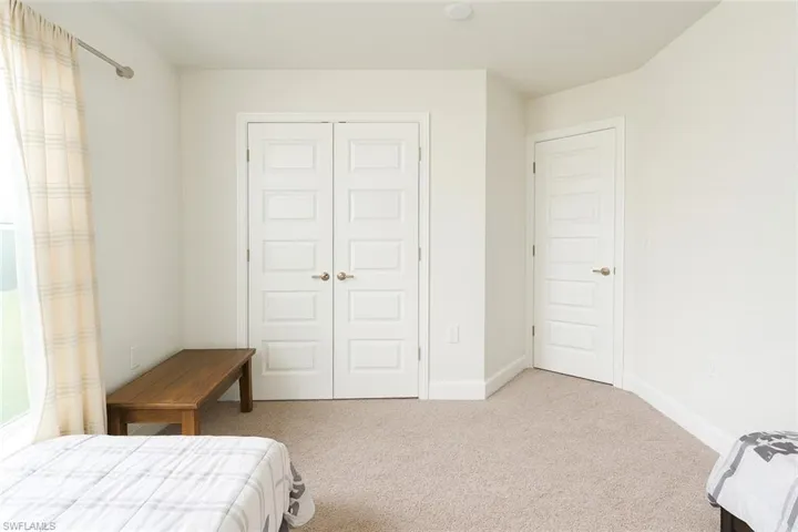 Bedroom featuring light carpet and a closet