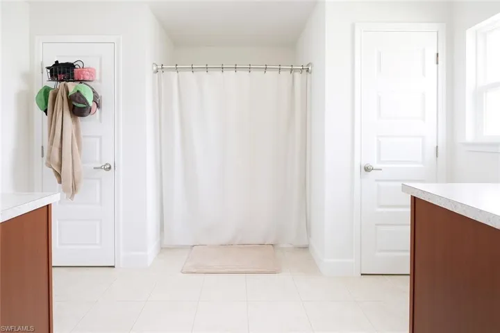 Bathroom with vanity, a stall shower, and light tile patterned floors