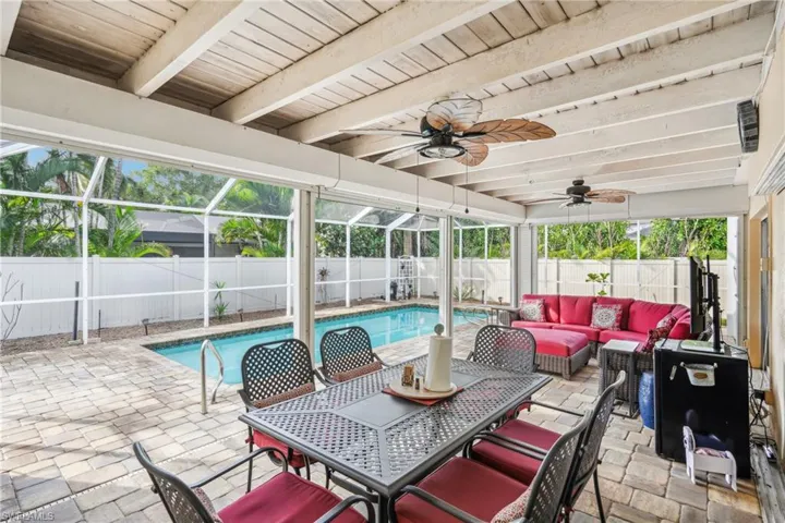 View of patio featuring glass enclosure, a fenced in pool, and an outdoor hangout area