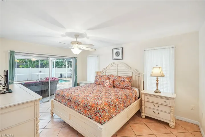 Tiled bedroom with access to outside and ceiling fan