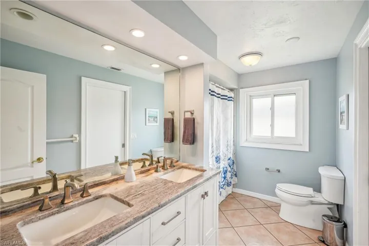 Bathroom with tile patterned floors, vanity, and toilet