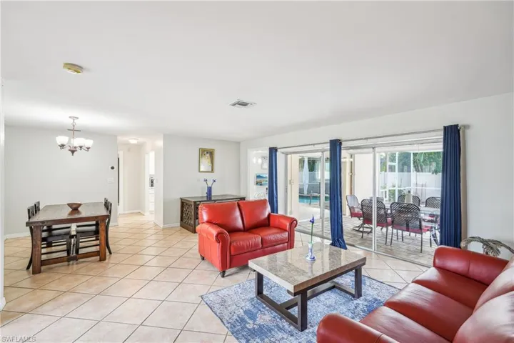 Living room with light tile patterned floors and an inviting chandelier