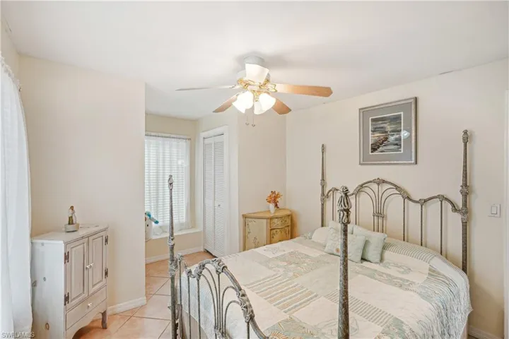 Bedroom with a closet, ceiling fan, and light tile patterned flooring