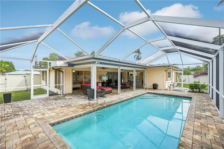 View of swimming pool with outdoor lounge area, a patio, ceiling fan, and a lanai
